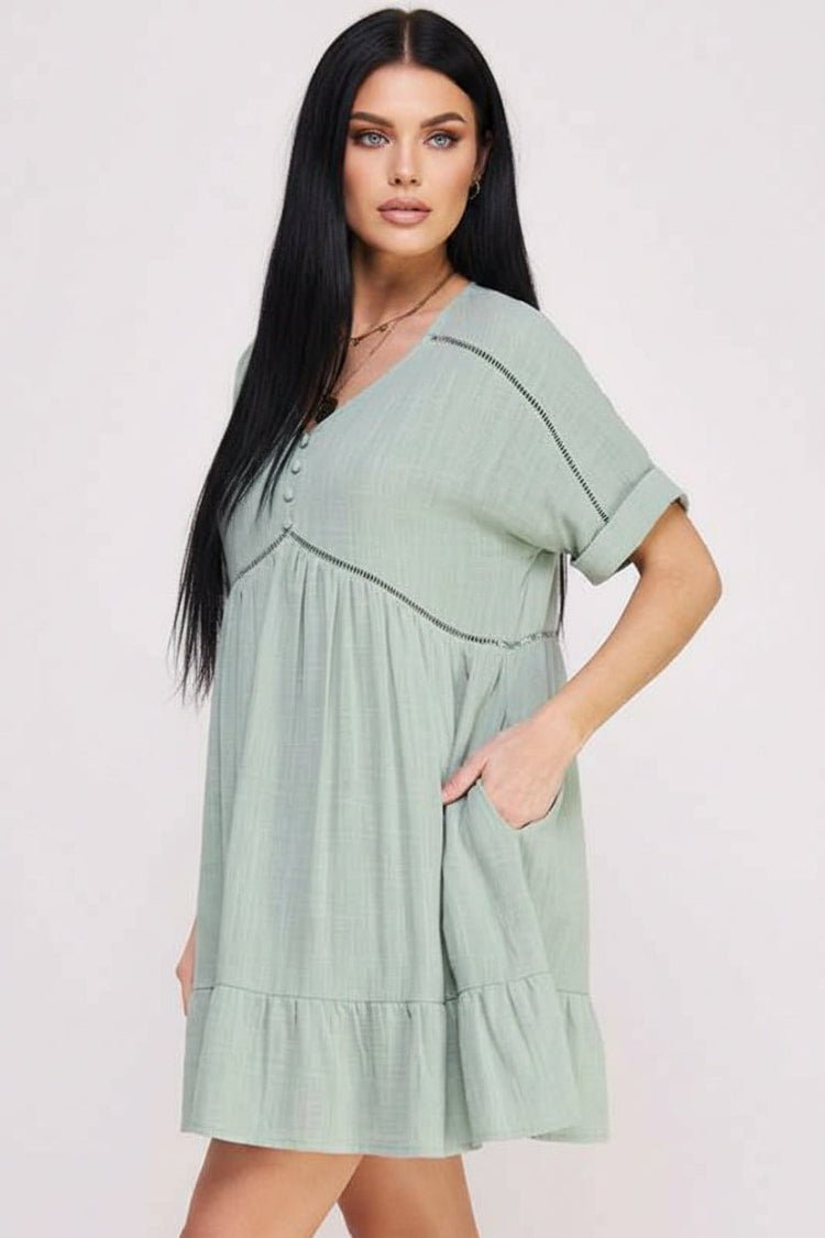 Woman wearing a light green dress with a plain background