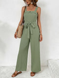 Woman wearing a green jumpsuit with a white background