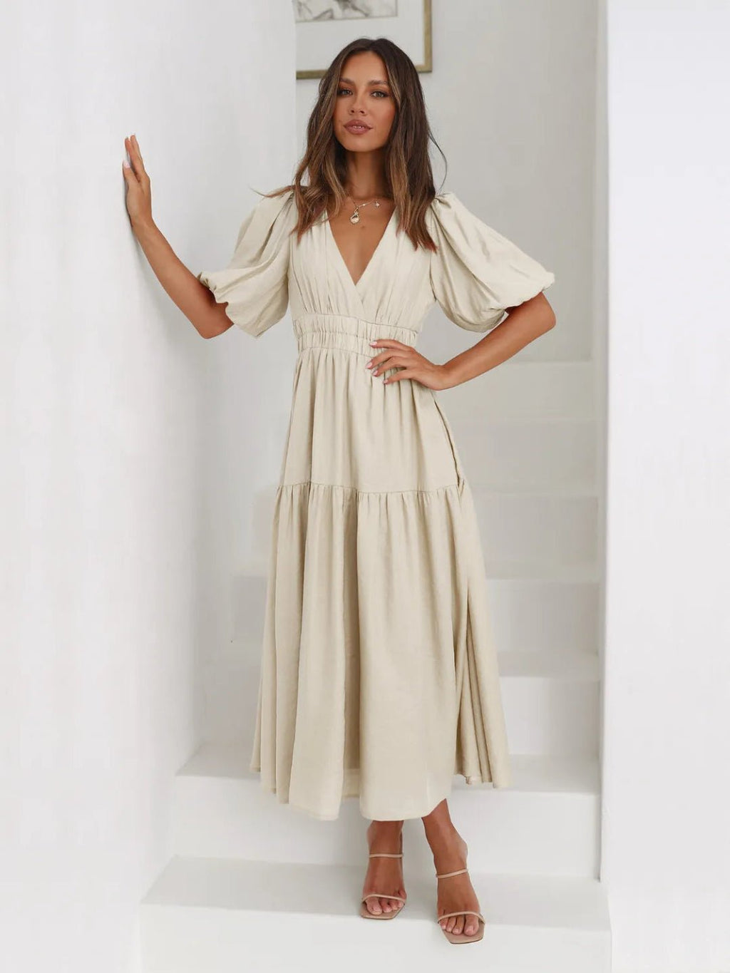 Woman wearing a beige dress against a white background