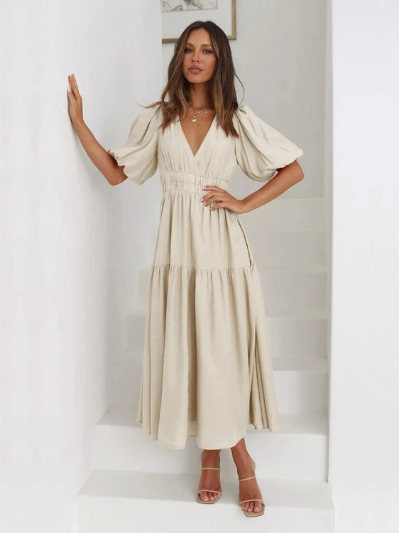Woman wearing a beige dress against a white background