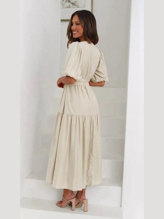 Woman wearing a beige dress in a minimal white room