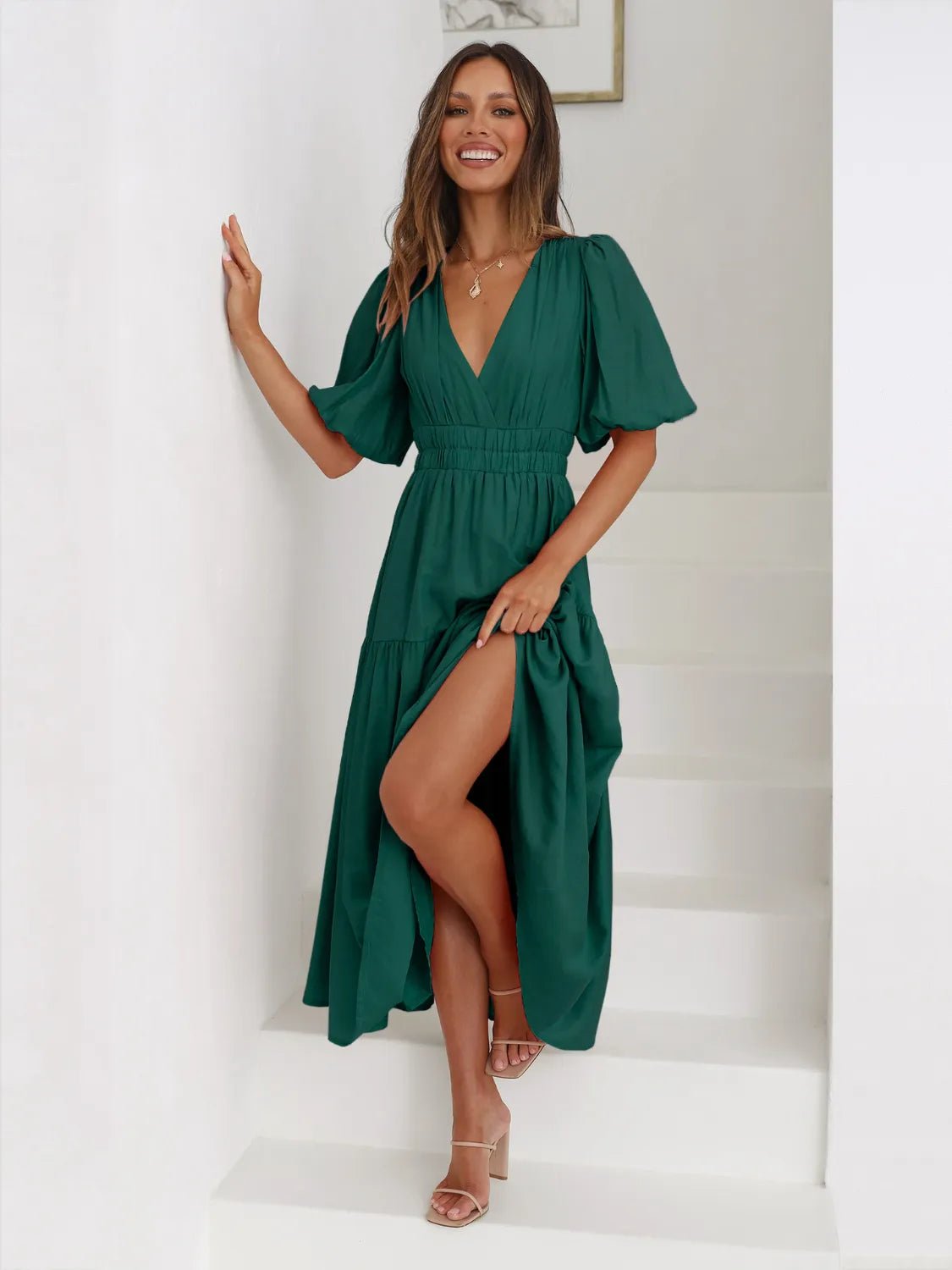 Woman wearing a green dress on a white staircase