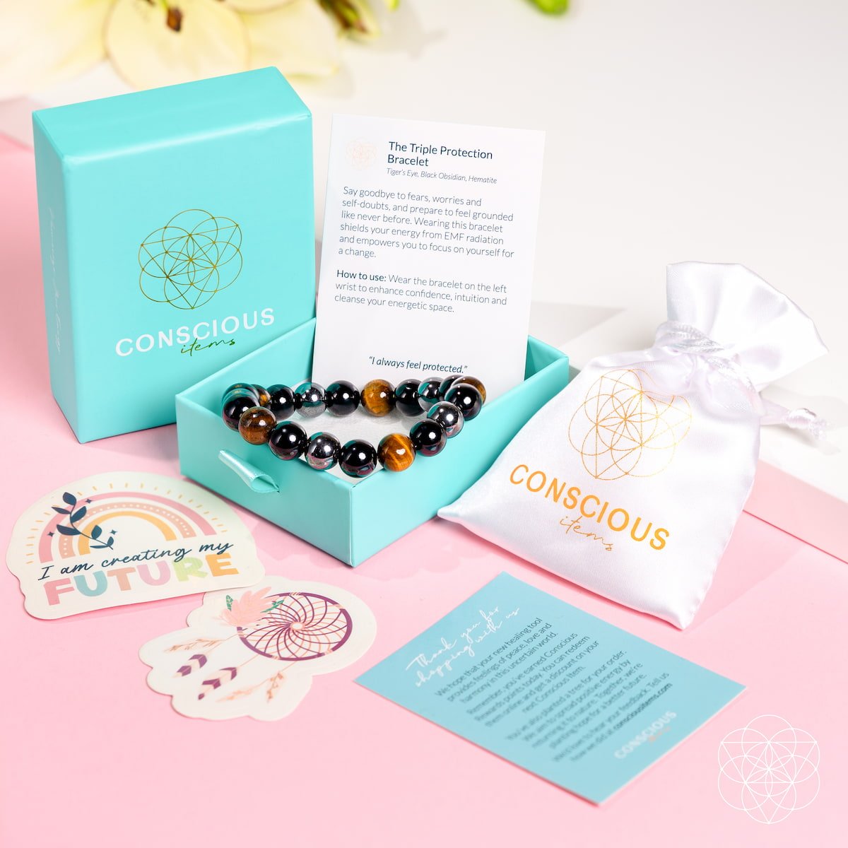 Conscious Living jewelry set with bracelet, box, and cards on a pink background