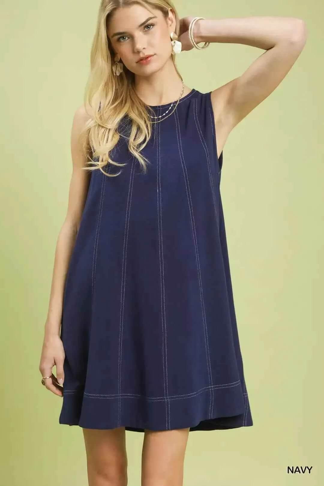 Woman wearing a navy dress on a light green background