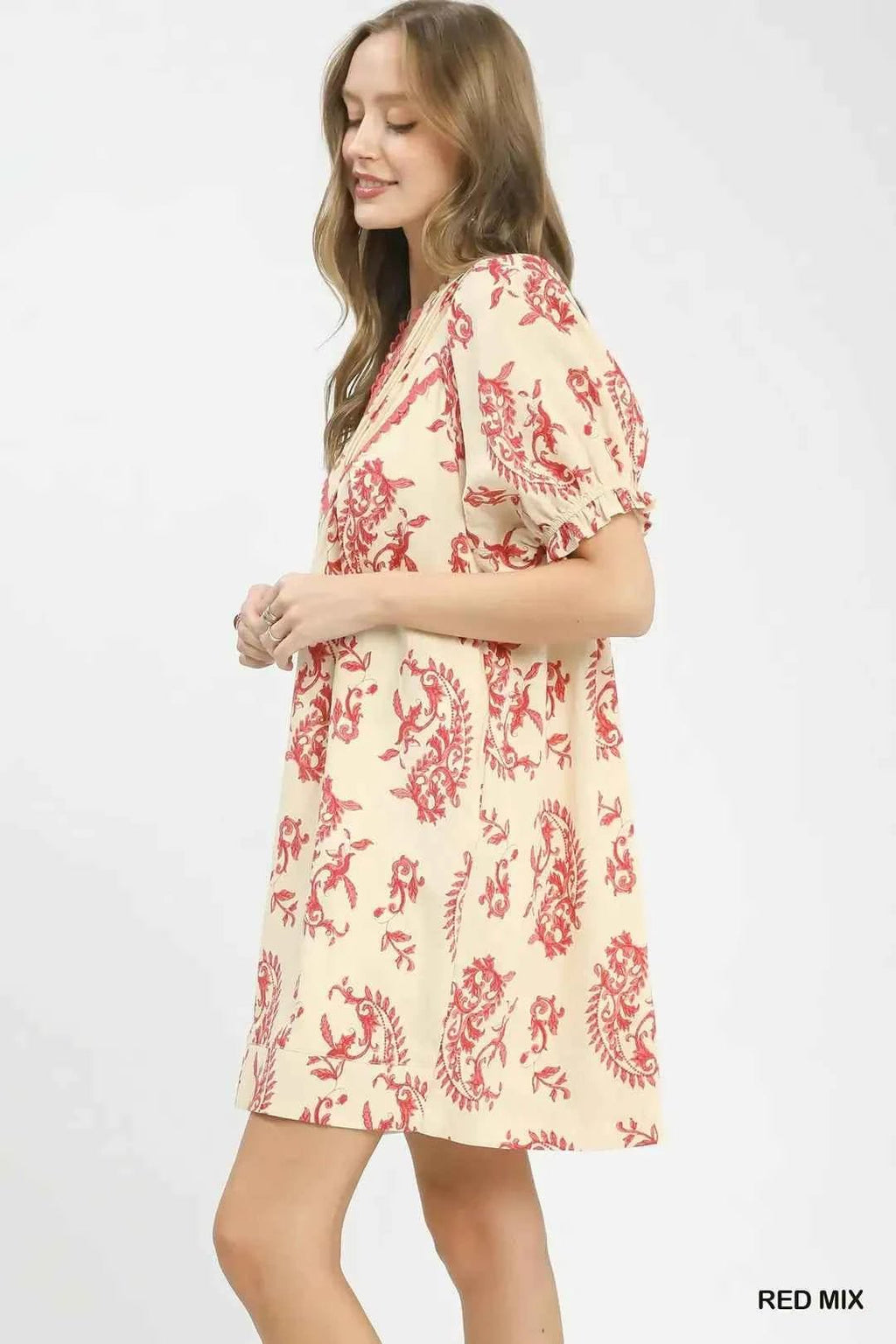 Woman wearing a red and white floral dress on a white background