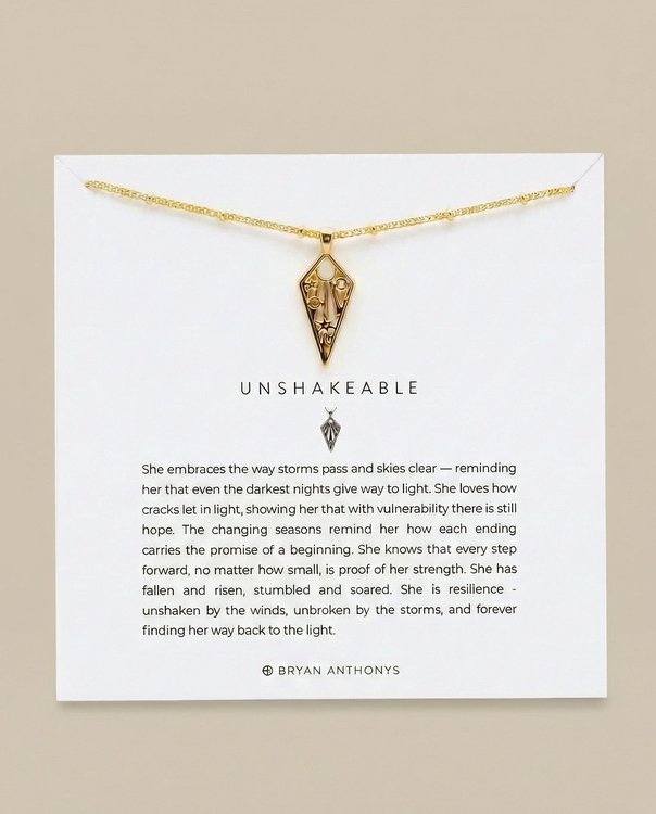 Gold Unshakeable necklace card featuring moon star symbols and brand logo