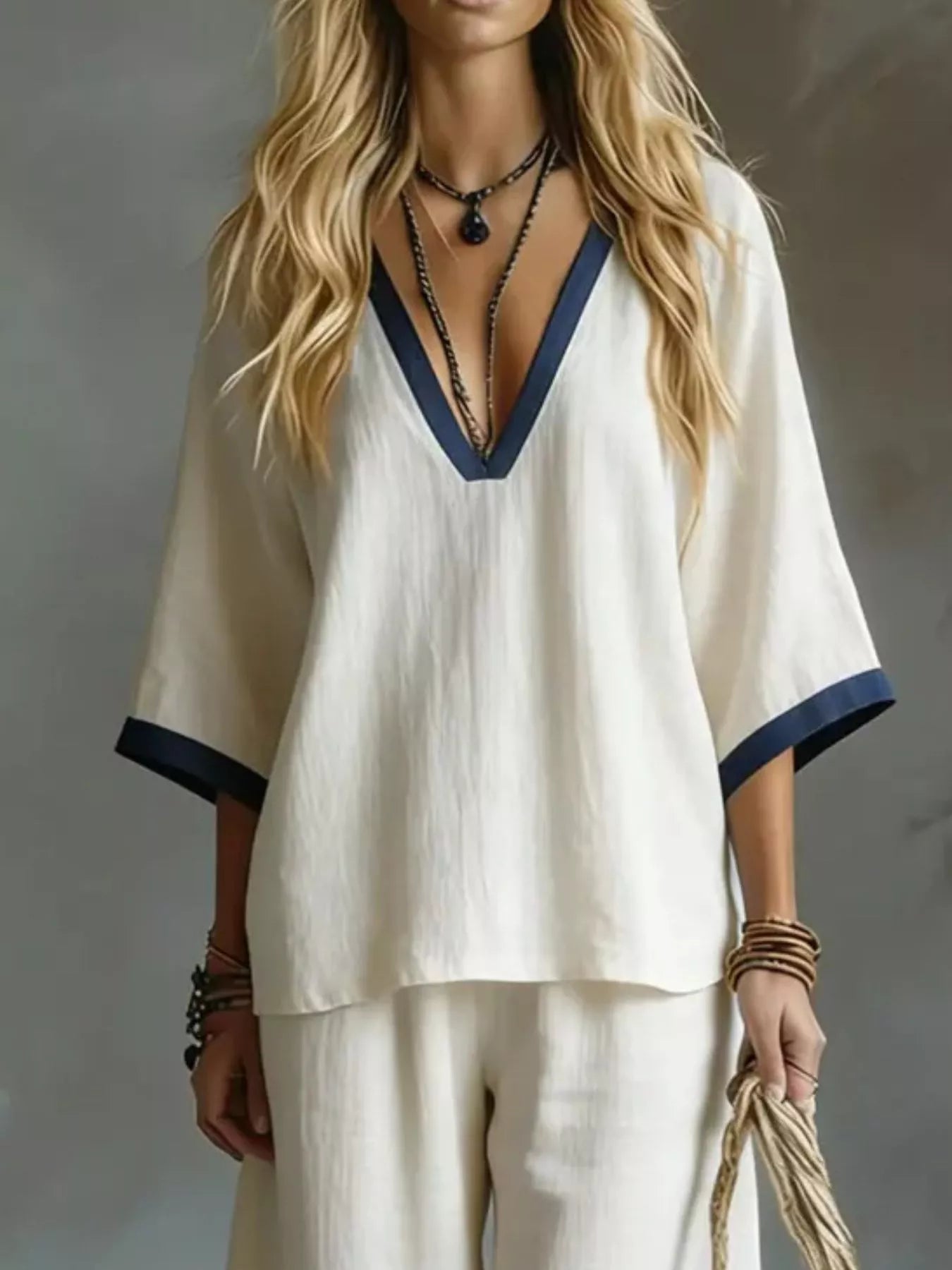 Woman wearing a white outfit with blue trim against a neutral background
