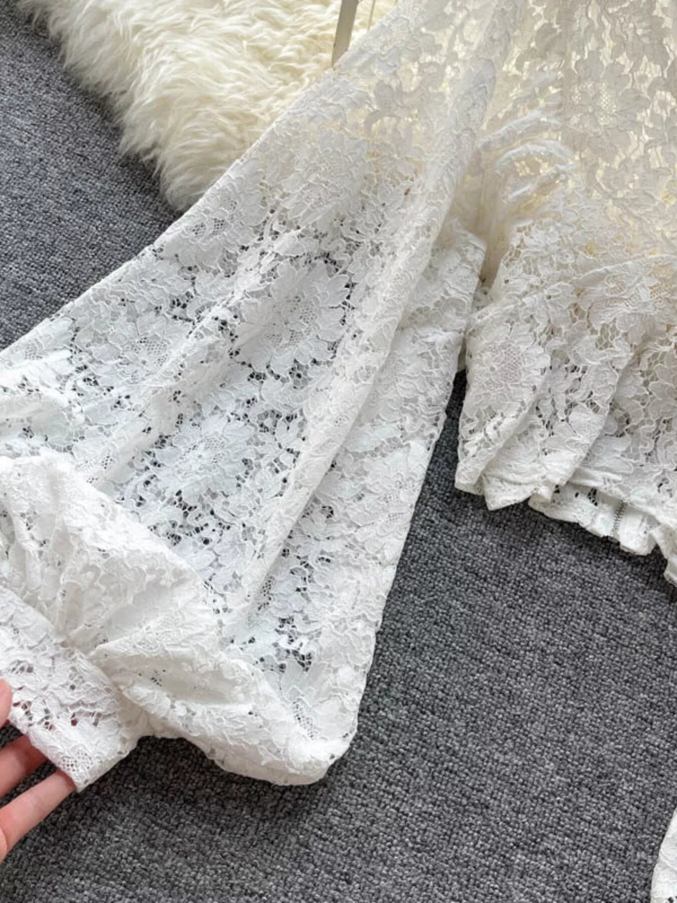 Close-up of white lace fabric on a gray surface
