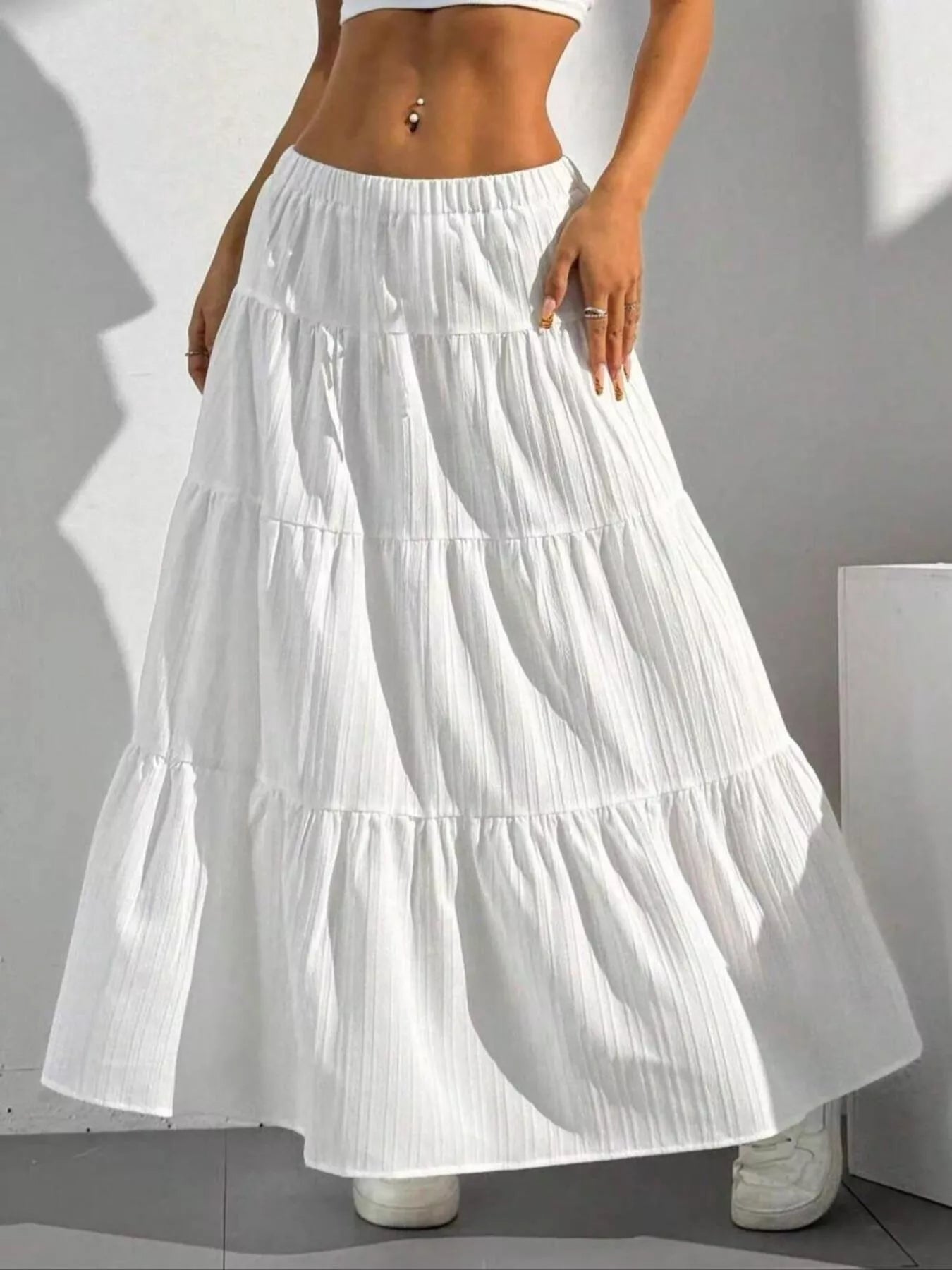 White tiered maxi skirt with shadow on white wall