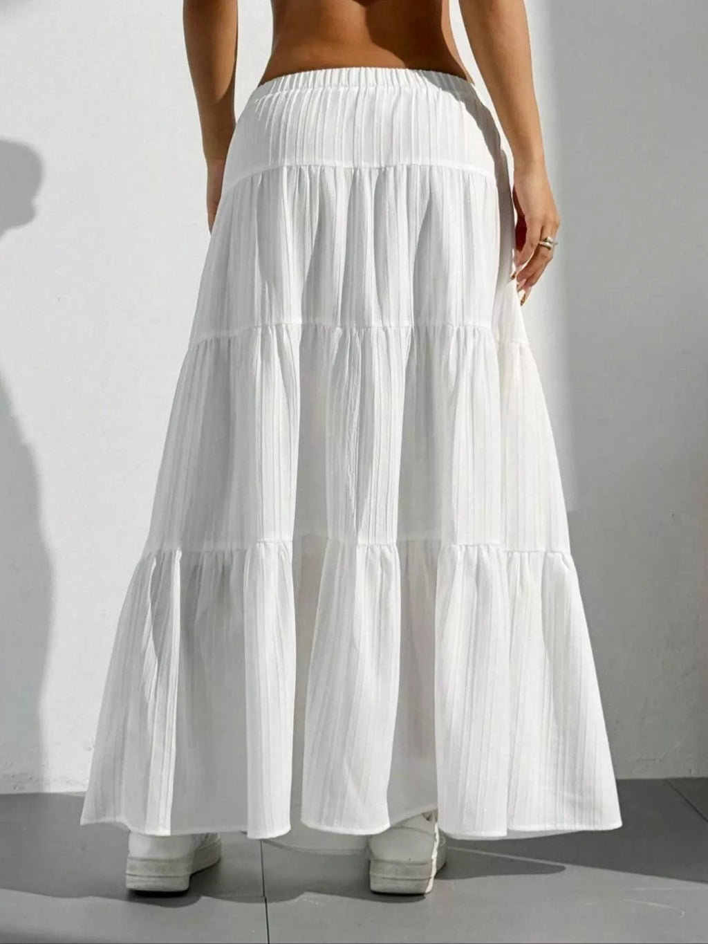 White tiered maxi skirt with shadow on white wall