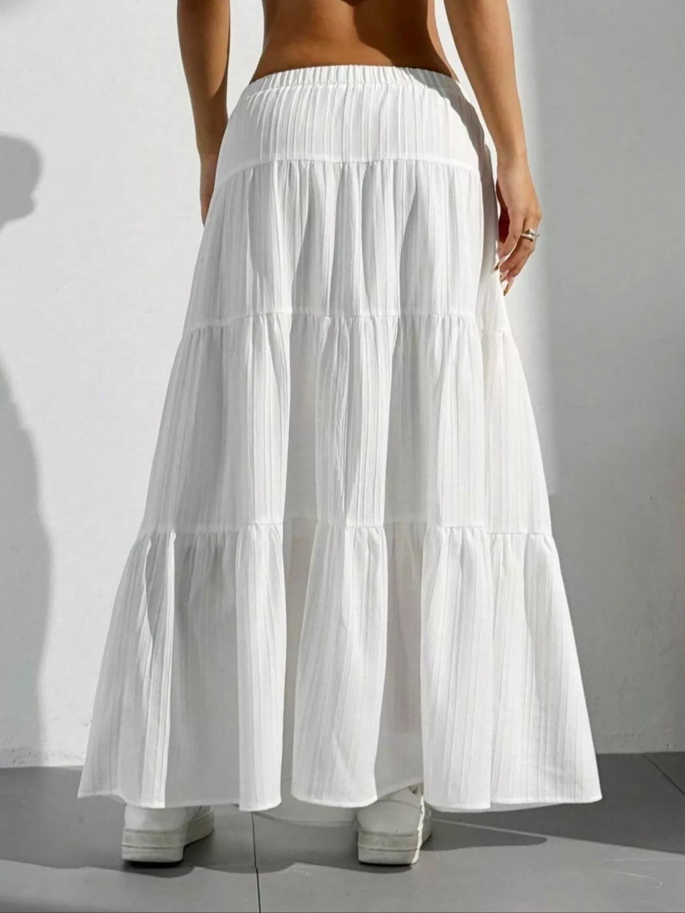 White tiered maxi skirt with shadow on white wall