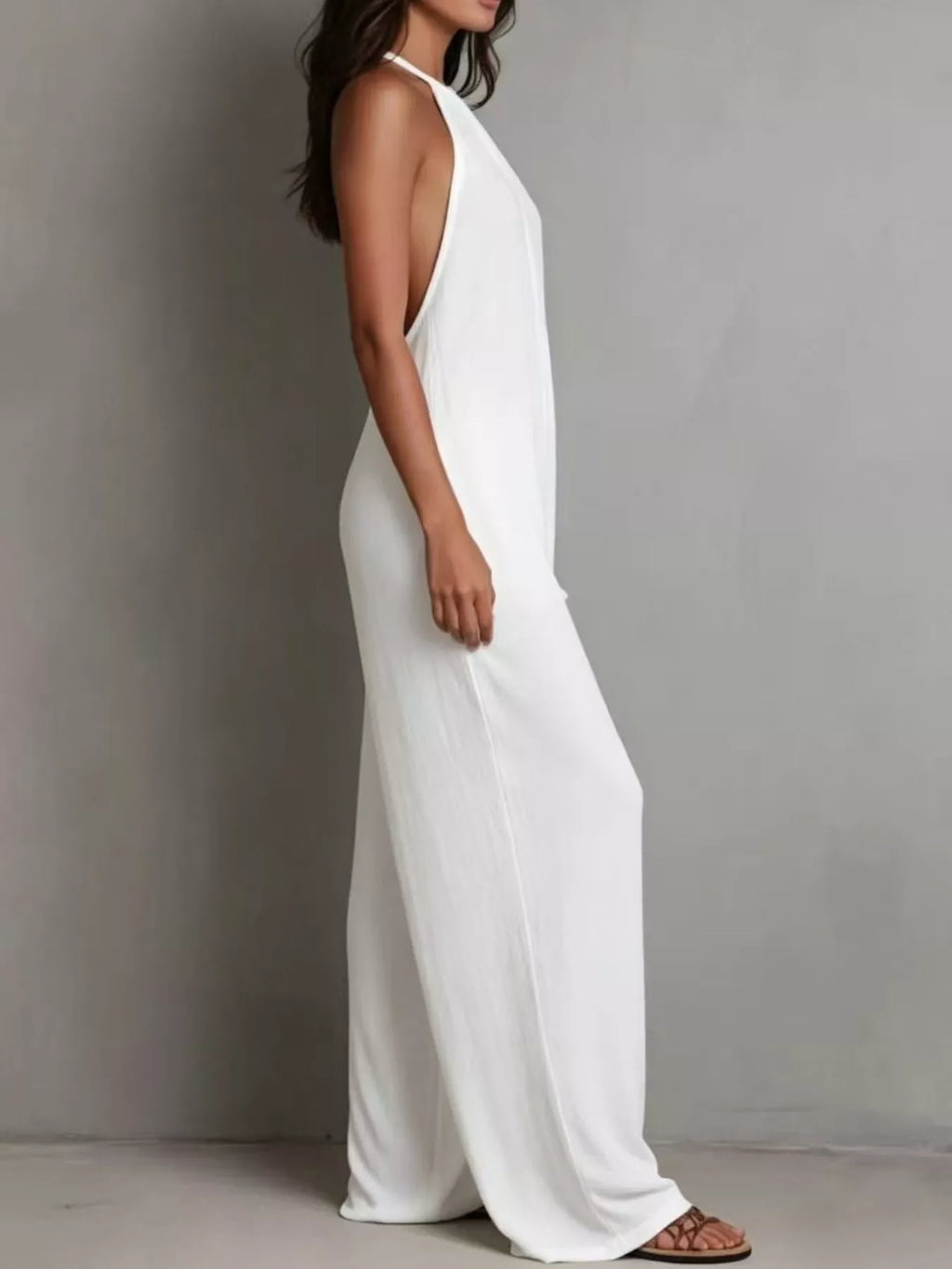 Woman wearing a white sleeveless dress against a gray background