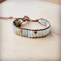 Detail shot of natural Amazonite cylindrical beads with woven brown cord texture