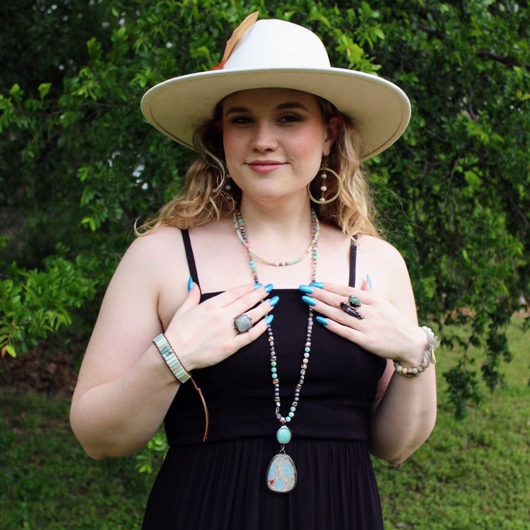 Woman wearing woven Amazonite stacked bracelet layered with necklace outdoors
