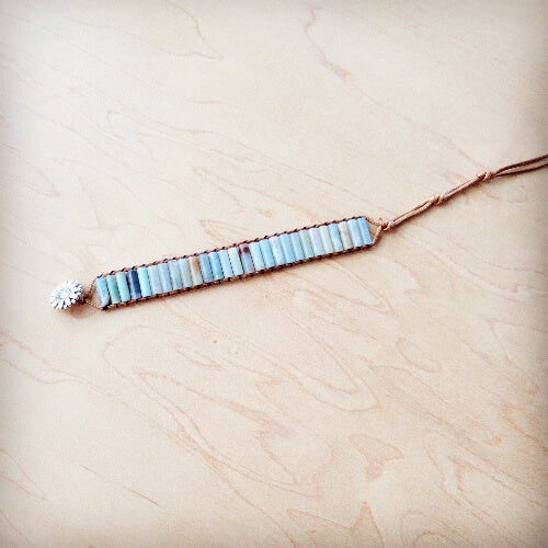 Bracelet with blue beads and a starfish charm on a light wooden surface