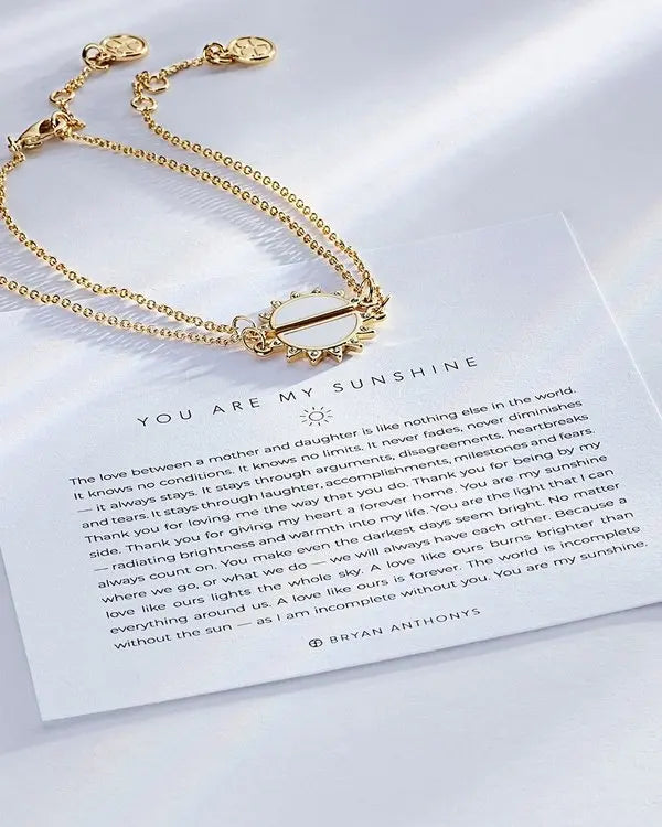 Gold sun charm bracelet displayed on 'You Are My Sunshine' message card