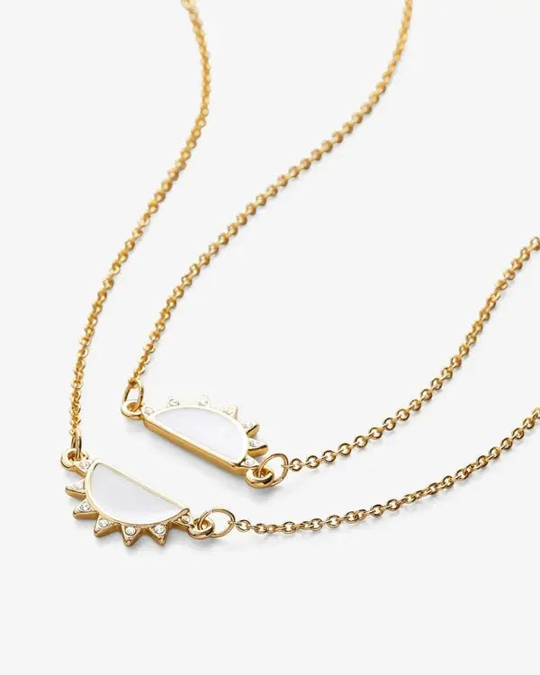 Two-sided view of gold half-sun charm bracelet set with white enamel center