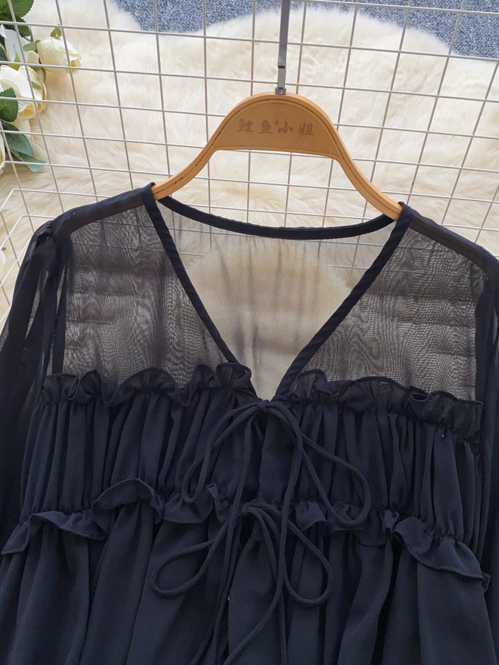 Blue blouse on a hanger against a tiled wall background