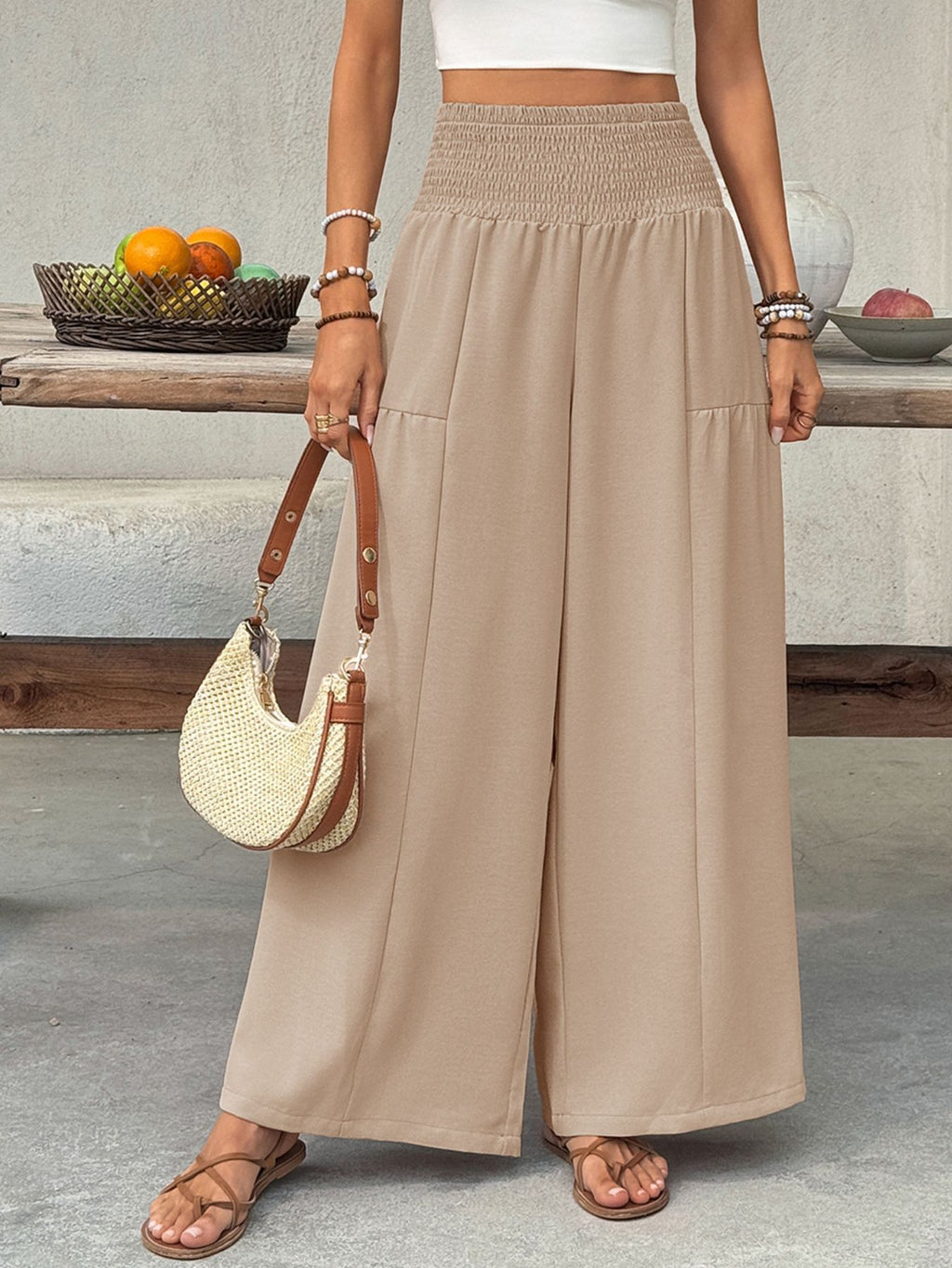 woman wearing Smocked Waist Wide Leg Pants holding a purse with brown shoes