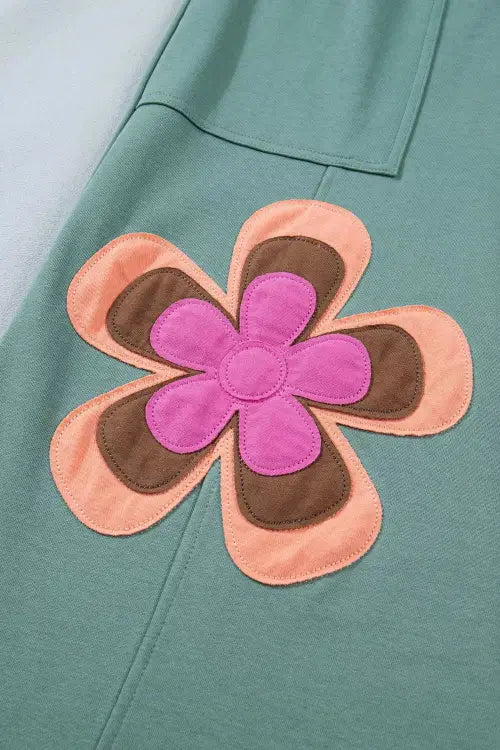 Floral patch with pink center and brown petals on a teal background