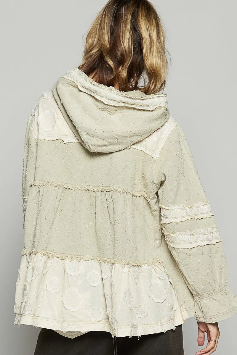 Light green hooded jacket with ruffled layers on a plain background