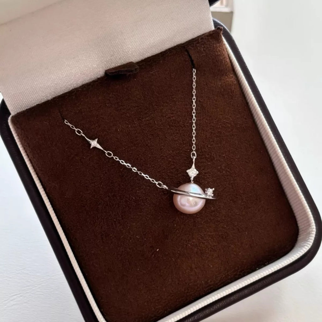 Pearl necklace with silver chain on a brown jewelry box