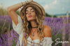 woman with hand on head in violet flower field