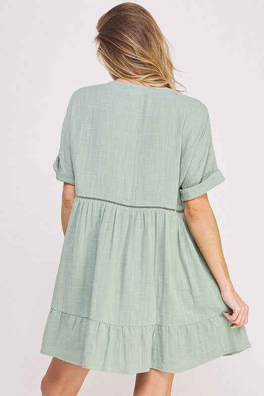 Woman wearing a light green dress with a plain background