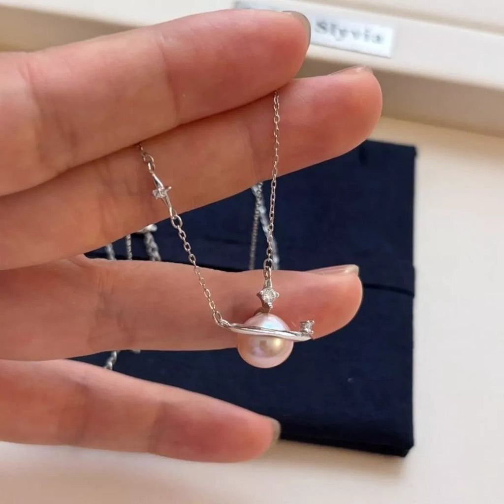 Hand holding a pearl necklace with a plain background