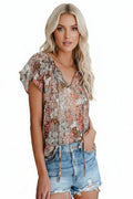 Woman wearing a floral blouse and denim shorts on a white background