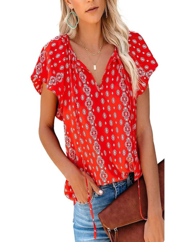 Woman wearing a red patterned blouse with denim shorts on a white background